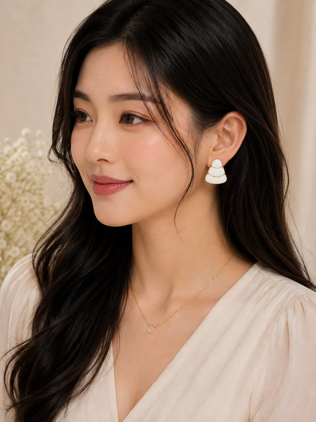 Model wearing ELORIA white enamel tiered drop earrings with gold detailing