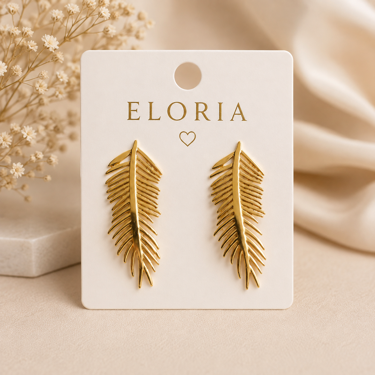 ELORIA gold leaf earrings displayed on a white jewellery card