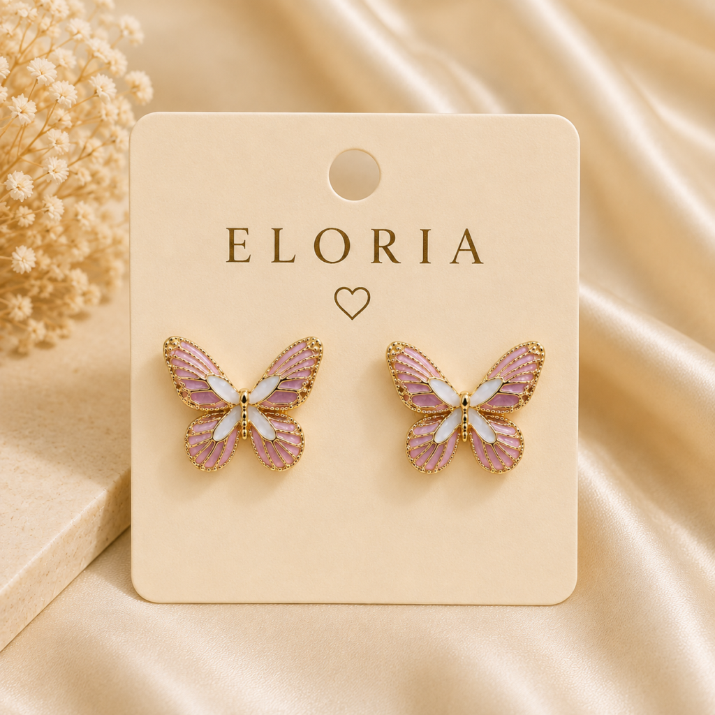 ELORIA pink and lilac butterfly stud earrings with gold-tone detailing displayed on an ivory jewelry card